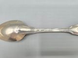 silver plated spoon and spoon rest on a white surface