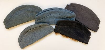 Plusieurs chapeaux sont alignés sur une surface blanche