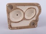 a brown and white ceramic object with holes in it