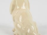 cream colored dog figurine sitting on a white surface