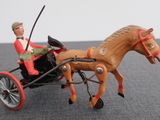 toy figurine of a man riding in a horse drawn carriage