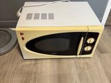 a microwave that is sitting on the floor next to a trash can