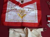 une table recouverte d'une nappe rouge, un tablier blanc, une paire de ciseaux, une paire de ciseaux et une paire de ciseaux