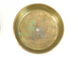 a gold plate sitting on a white surface next to a silver plate