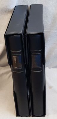 three black books are stacked on top of each other on a white surface