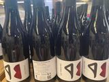 plusieurs bouteilles de vin rouge sont posées sur une étagère dans un magasin
