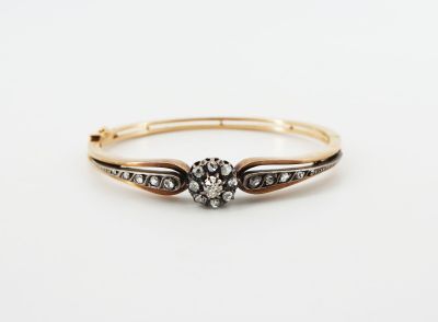 a gold and diamond ring with a flower design on the side