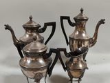 deux théières en argent et une cafetière posées sur une table