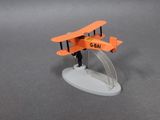 a small model of an orange airplane on a white base