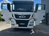 Le camion est garé devant un immeuble par une journée ensoleillée.