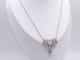 a white mannequin with a silver necklace on a wooden stand