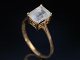 an image of a gold ring with a white topazte stone