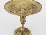 une assiette en or ornée d'un motif représentant un oiseau et des fleurs
