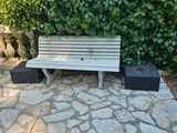 un banc en bois posé au milieu d'une allée pavée