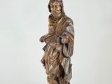 an old statue of a man with a beard holding a bag