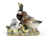une figurine représentant un canard et un caneton assis sur un rocher
