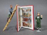 two figurines that are standing next to a book