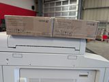 two boxes on top of a printer that is sitting on top of it
