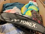 a cardboard box full of tennis rackets and other items