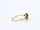 a close up of a gold ring with a black diamond