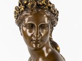 bronze statue of a woman with a wreath on her head