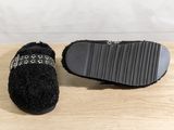 the black slippers are on top of a wooden table