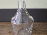 a clear glass bottle sitting on a wooden table