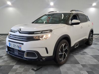 Le SUV Citrole blanc est garé dans une grande pièce.