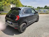 a small black car parked on the side of the road