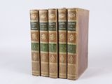 trois livres sont empilés sur une surface blanche