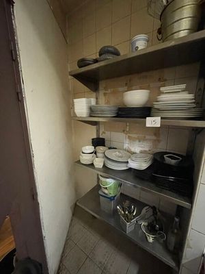 many plates and pans on the shelves in the kitchen