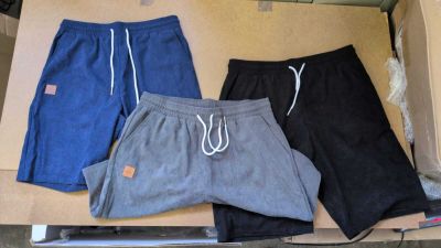 three pairs of men ' s shorts sitting in a box