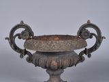 an old metal bowl with a handle on a white surface