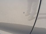 a reflection of a person standing on the side of a car