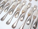 many forks and spoons laid out on the table