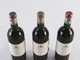 three bottles of wine sitting next to each other on a white surface
