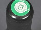 a close up of a black bottle with a green label on it