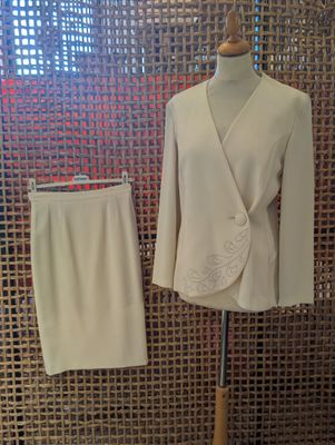 a white suit and a white skirt on a mannequin stand