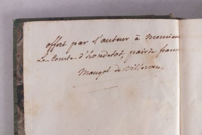 un vieux livre écrit posé sur une table