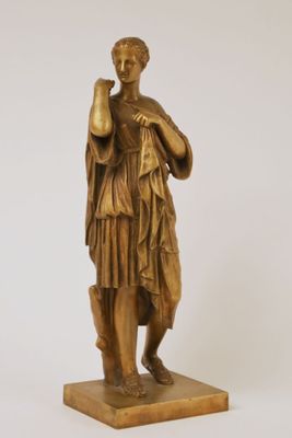 bronze statue of a woman holding a bottle of wine