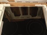 une boîte posée par terre, contenant une plaque de cuisson à l'intérieur