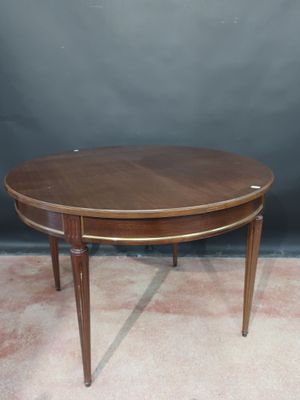 an oval coffee table with a wooden top on a carpeted floor