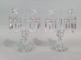 three crystal candlesticks sitting on a white table