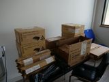 plusieurs cartons posés sur une table, avec une chaise devant celle-ci