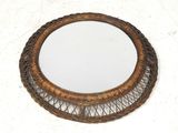 une image représentant un miroir rond en osier posé sur une surface blanche