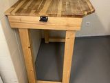 a small table with a wooden top in the corner of a room