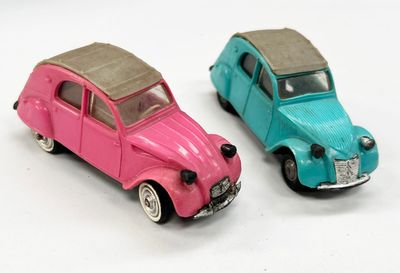 deux petites voitures posées côte à côte sur une surface blanche