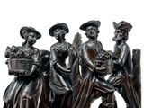 three figurines of women holding baskets of fruit