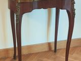 une petite table en bois avec un plateau en marbre, posée sur un parquet en bois massif