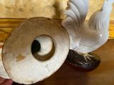 a person holding a white vase and a white bird on a table